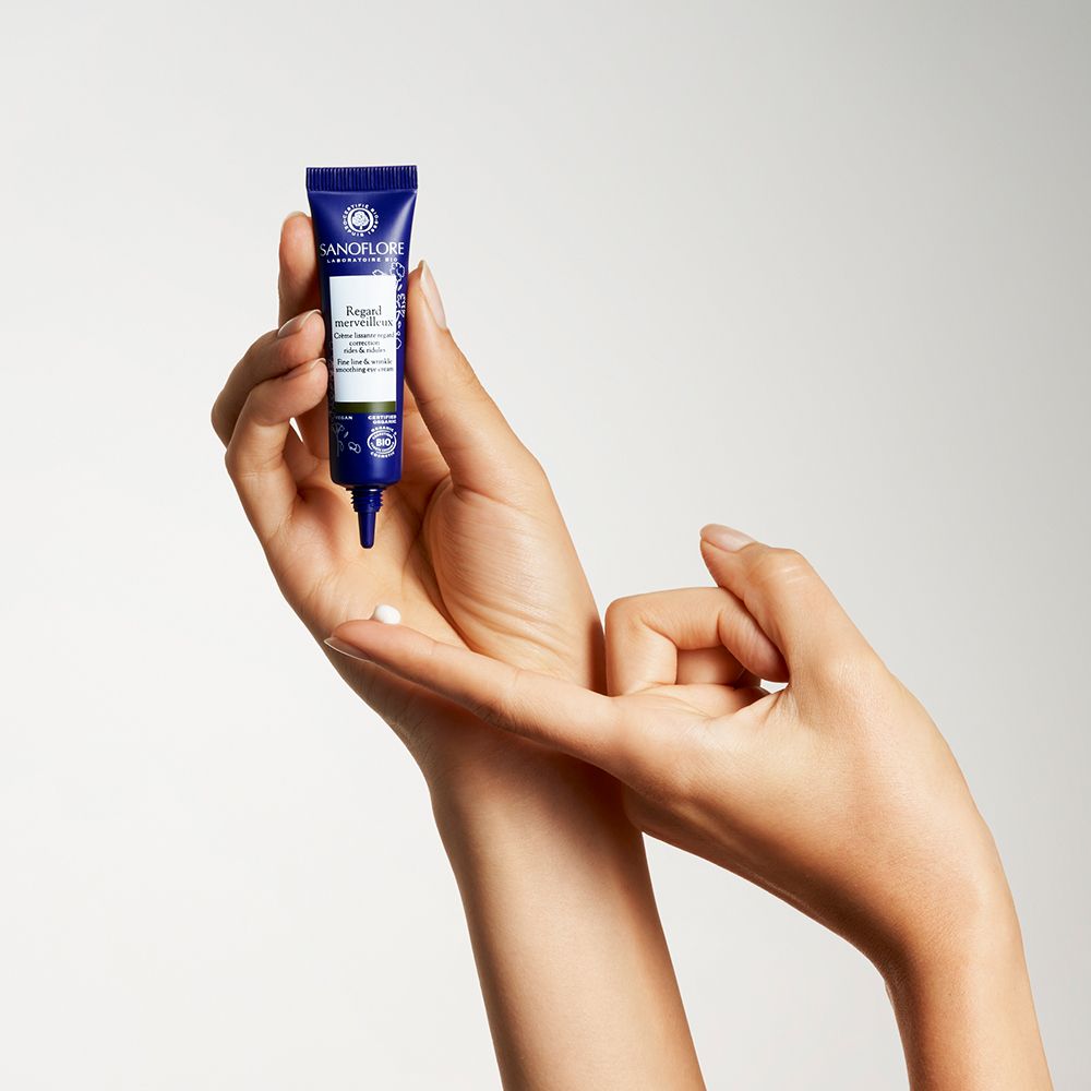 Mains tenant un tube de crème pour les yeux. Texte: Sanoflore, Regard merveilleux.