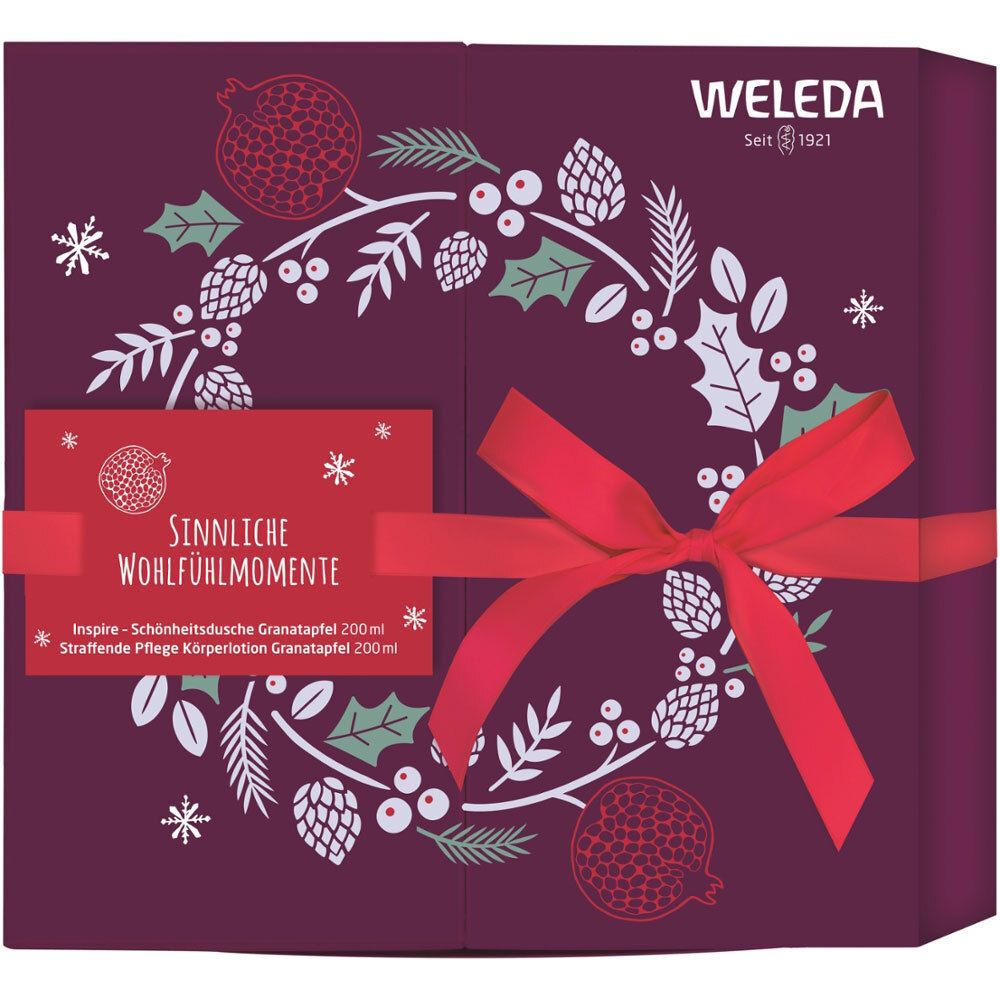 Coffret cadeau avec ruban rouge. Inscription : Sinnliche Wohlfühlmomente. Décoration avec motifs de grenade et logo Weleda.