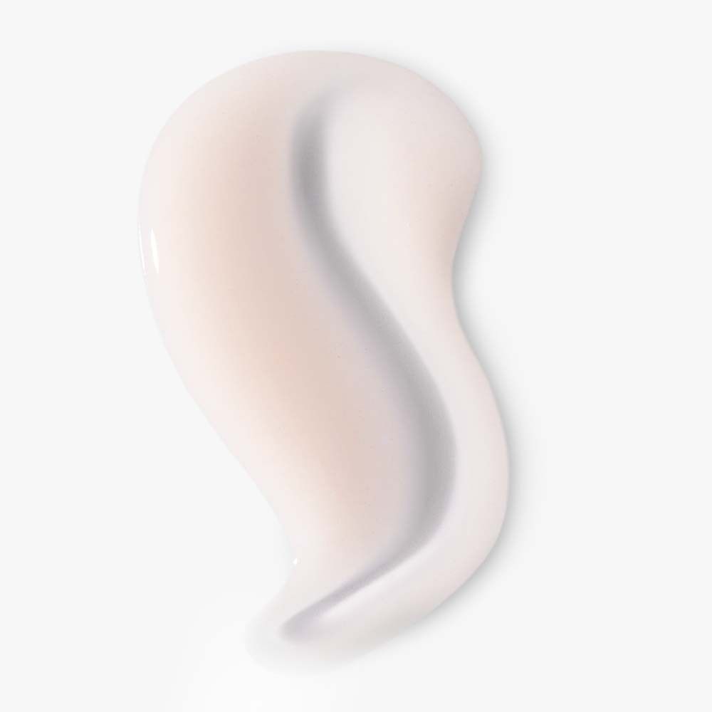 Gros plan d'une trace de sérum crémeux et blanc. Texture lisse, étalée sur fond clair.