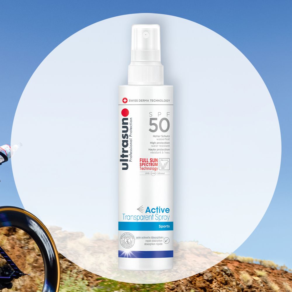 Spray blanc avec tête de pulvérisation. Inscription : ultrasun, SPF 50, Active Transparent Spray Sports. Arrière-plan : cycliste.