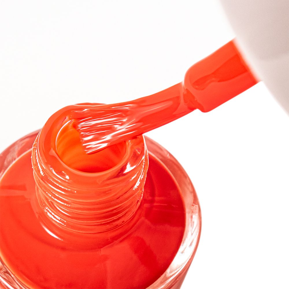 Pinceau de vernis dans un flacon de vernis. Vernis à ongles rouge. Pinceau imbibé de vernis. Flacon rempli de vernis rouge.