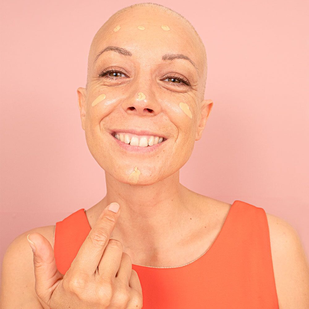 Femme avec traces de crème sur le visage. Teinte Medium. Pour peaux sensibles.
