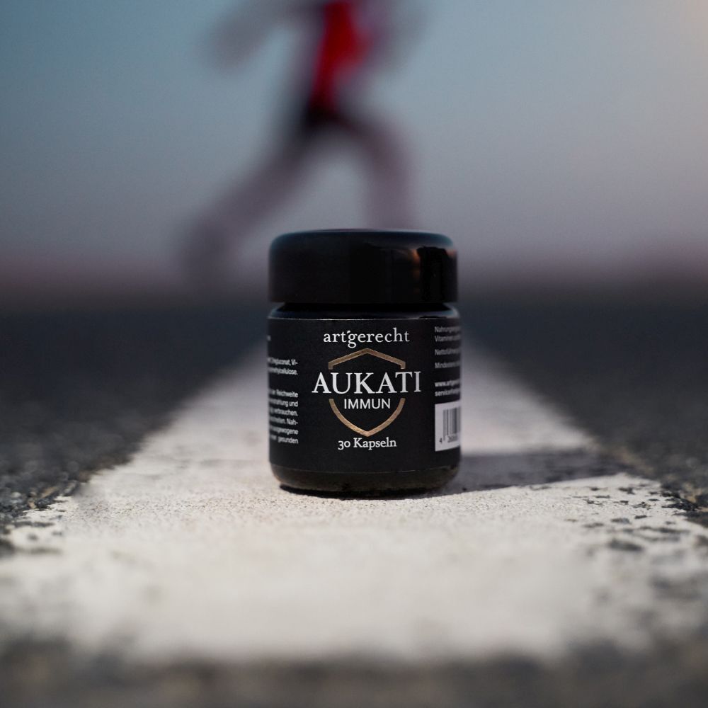 Schwarze Dose mit Aufschrift AUKATI IMMUN, 30 Kapseln, auf Straße. Schwarzer Deckel.