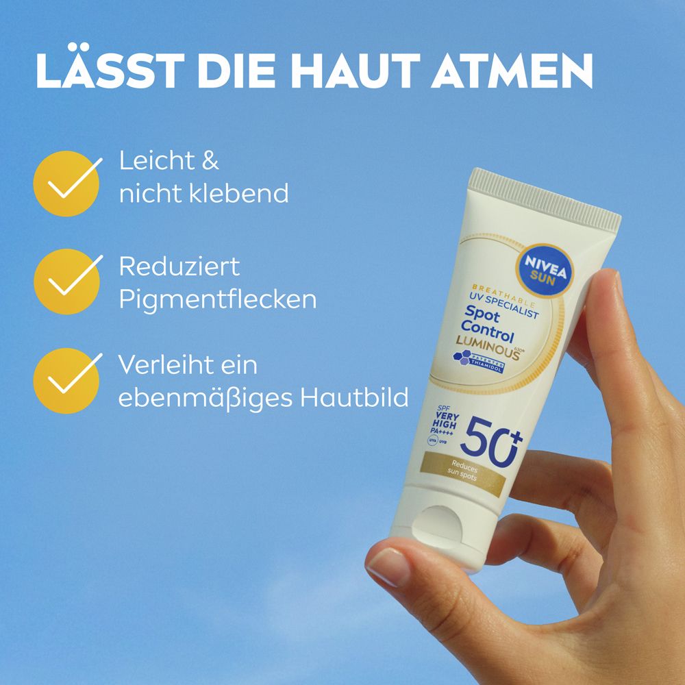 Hand hält NIVEA SUN UV Gesicht Experte Anti-Pigmentflecken Luminous 50+ Sonnencreme vor blauem Himmel.