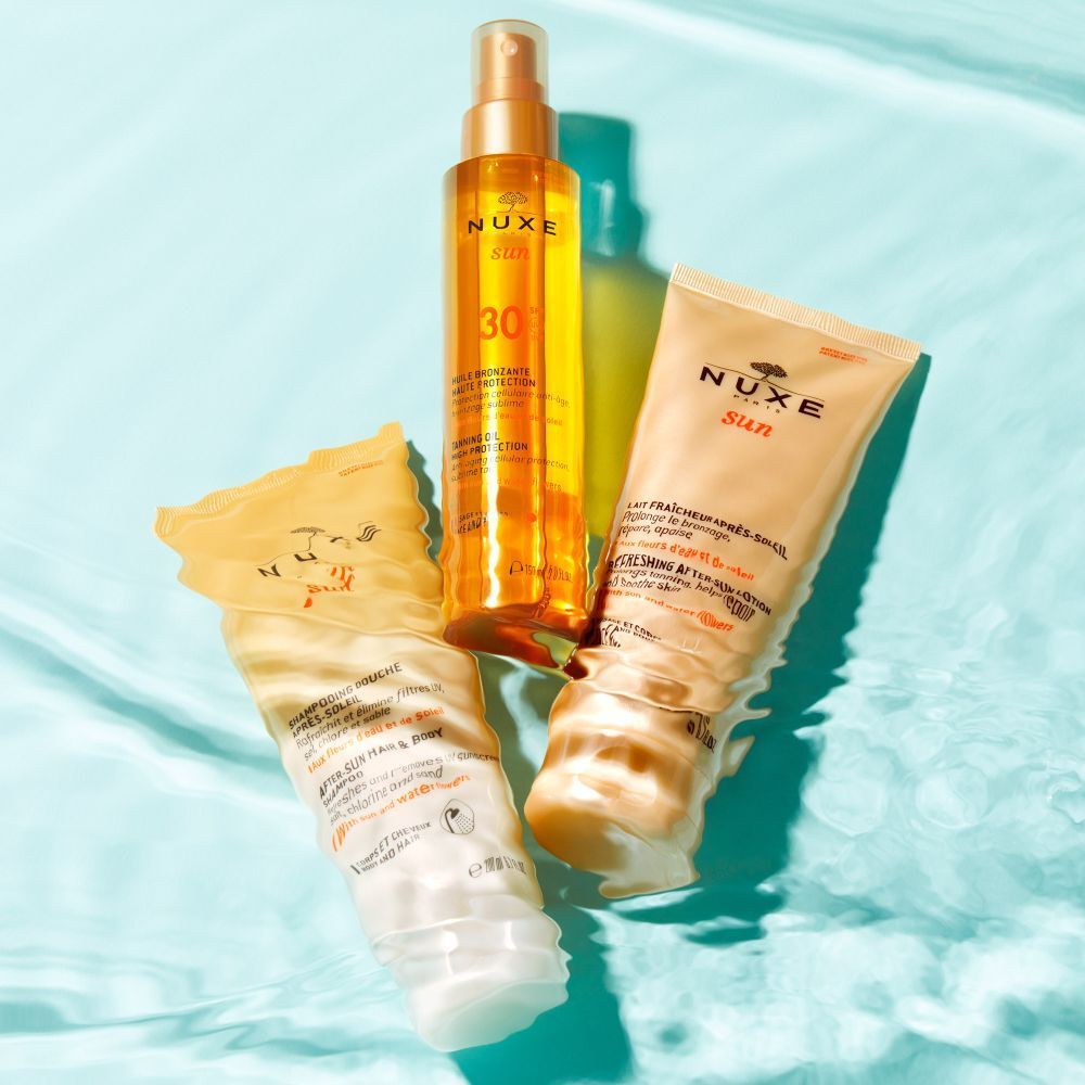 Trois produits NUXE Sun dans l'eau. Lait solaire, huile et après-soleil.
