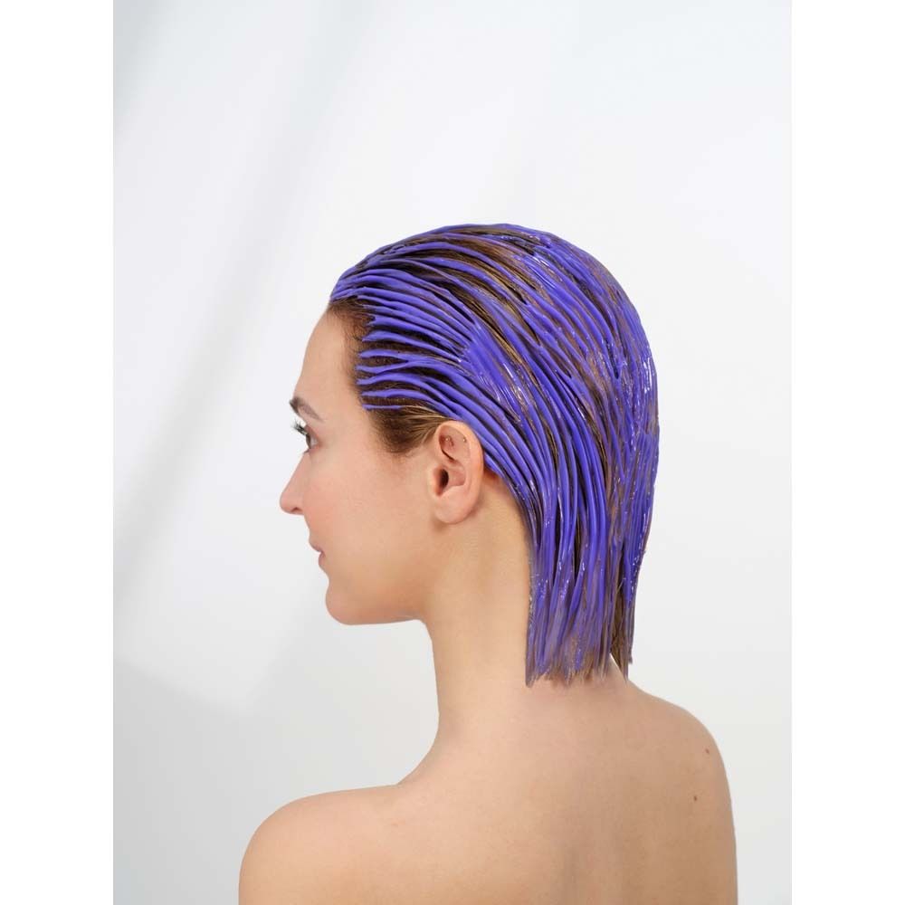 Femme aux cheveux teints en violet. Vue de côté. Fond blanc.