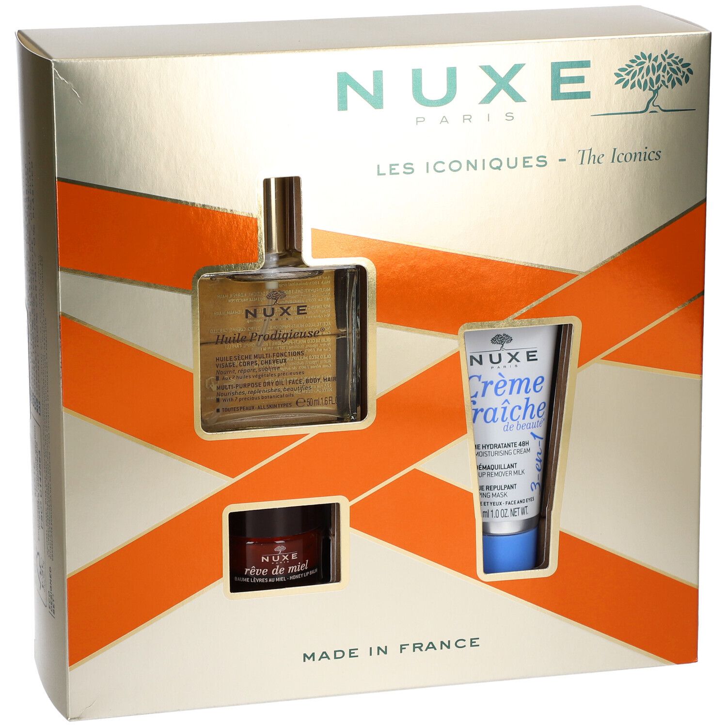 Geschenkbox mit drei NUXE-Produkten. Sichtbar: Öl, Creme und Balsam. Goldene Verpackung mit orangefarbenen Akzenten. "Les Iconiques".