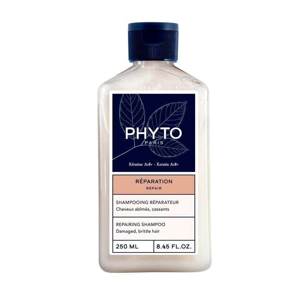 Shampoo-Flasche mit blauem Deckel. Etikett mit Logo und Produktbezeichnung: Réparation. Text: Shampooing réparateur, Cheveux abîmés, cassants.