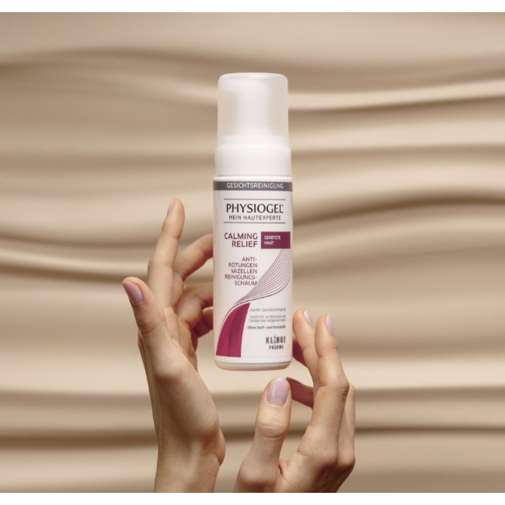 Mains tenant un flacon blanc. PHYSIOGEL Calming Relief Mousse Nettoyante Micellaire. Klinge Pharma.