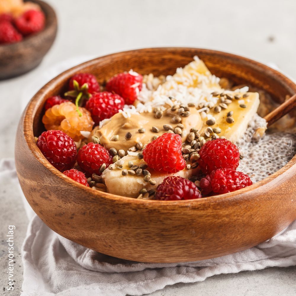 Schüssel mit Beeren, Banane und Samen. Aufschrift: Servier Vorschlag.
