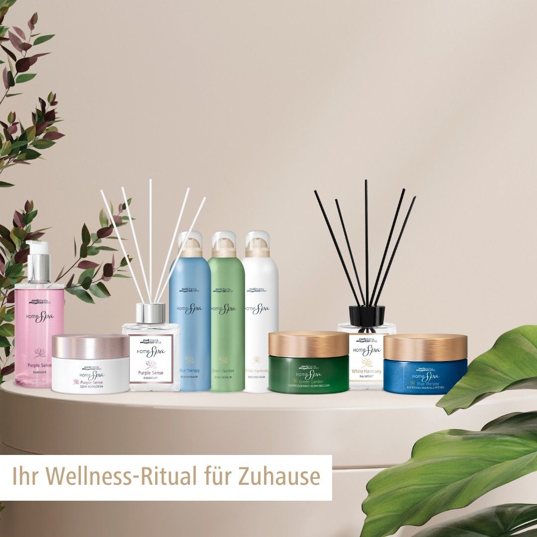 Différents produits sur un piédestal. Diffuseur d'ambiance, crèmes, sprays. Produits avec étiquette blanche et différentes couleurs.