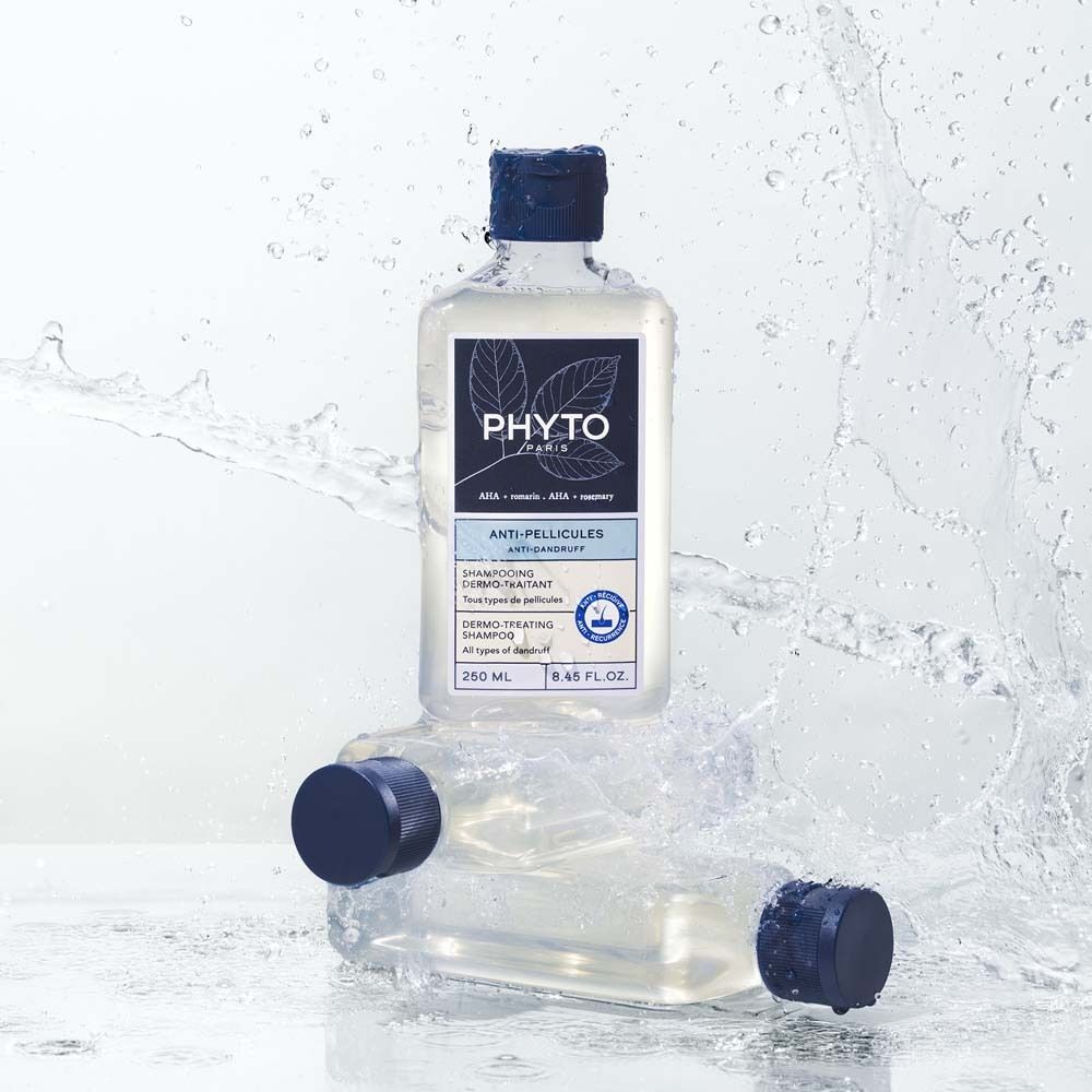 Zwei Shampoo-Flaschen mit blauem Deckel, umgeben von Wasser. Produktinformationen auf dem Etikett.