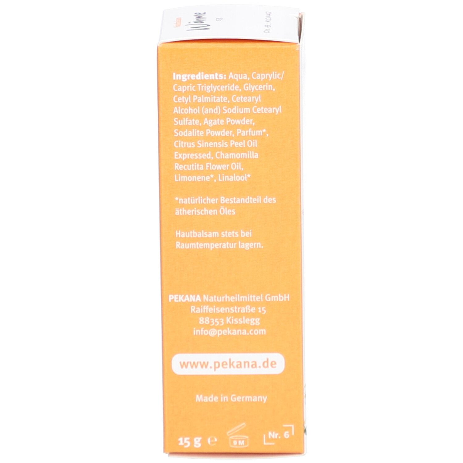 Dos de l'emballage du produit. Liste des ingrédients, coordonnées et adresse du fabricant. Fond orange.