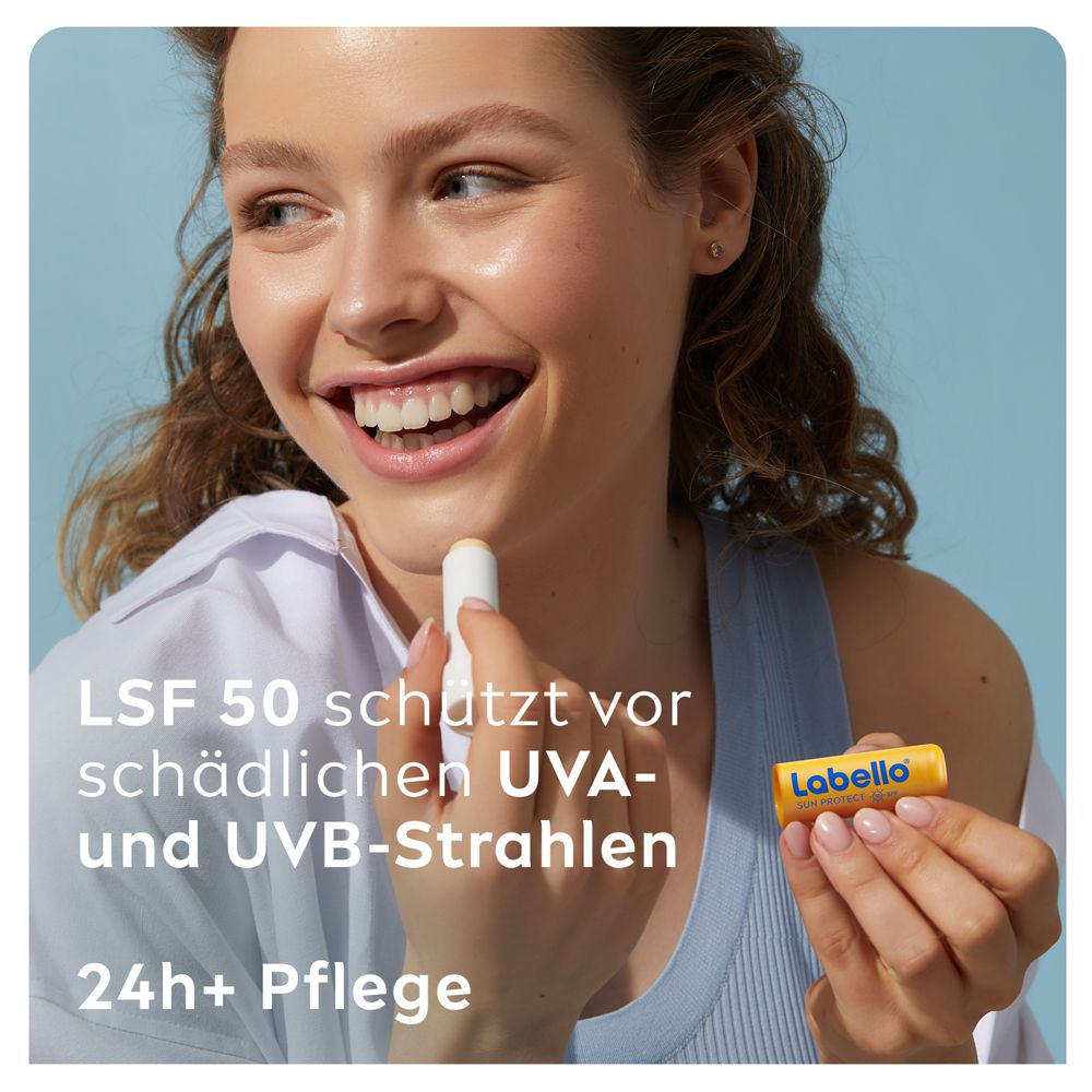 Jeune femme appliquant du baume à lèvres Labello SUN PROTECT, tenant le stick dans sa main.