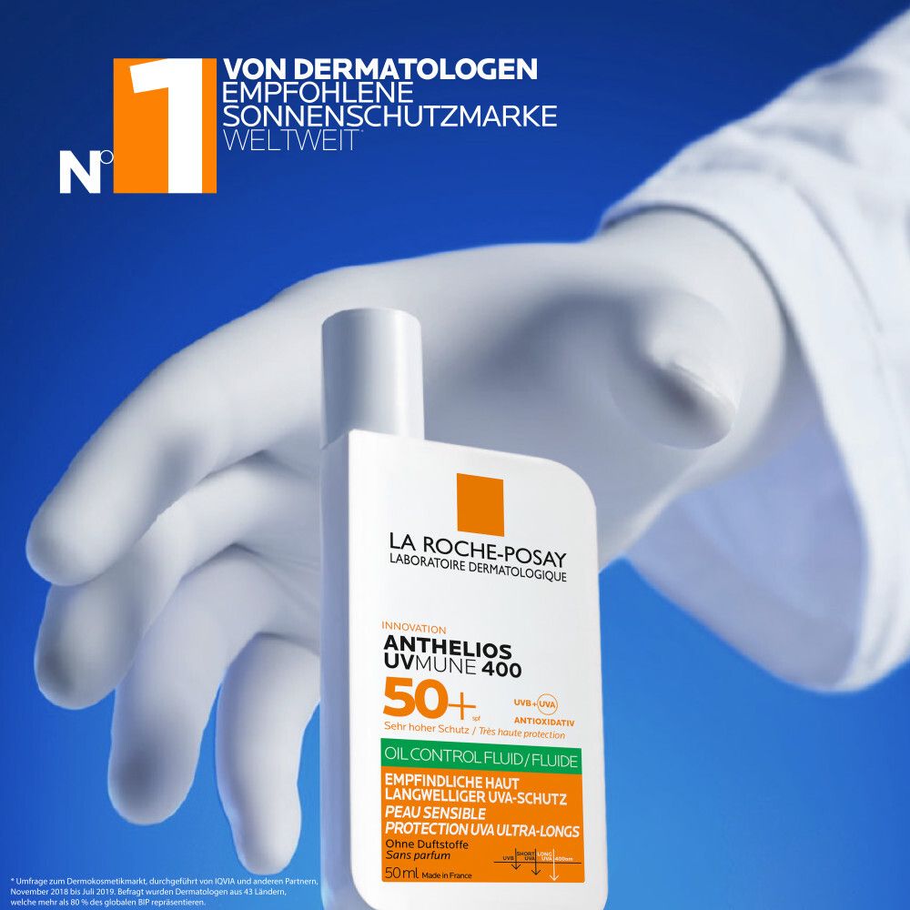 La Roche-Posay Anthelios Oil Control Fluid SPF 50+ crème solaire dans un flacon blanc, tenue par une main gantée. N°1 marque solaire recommandée par les dermatologues.
