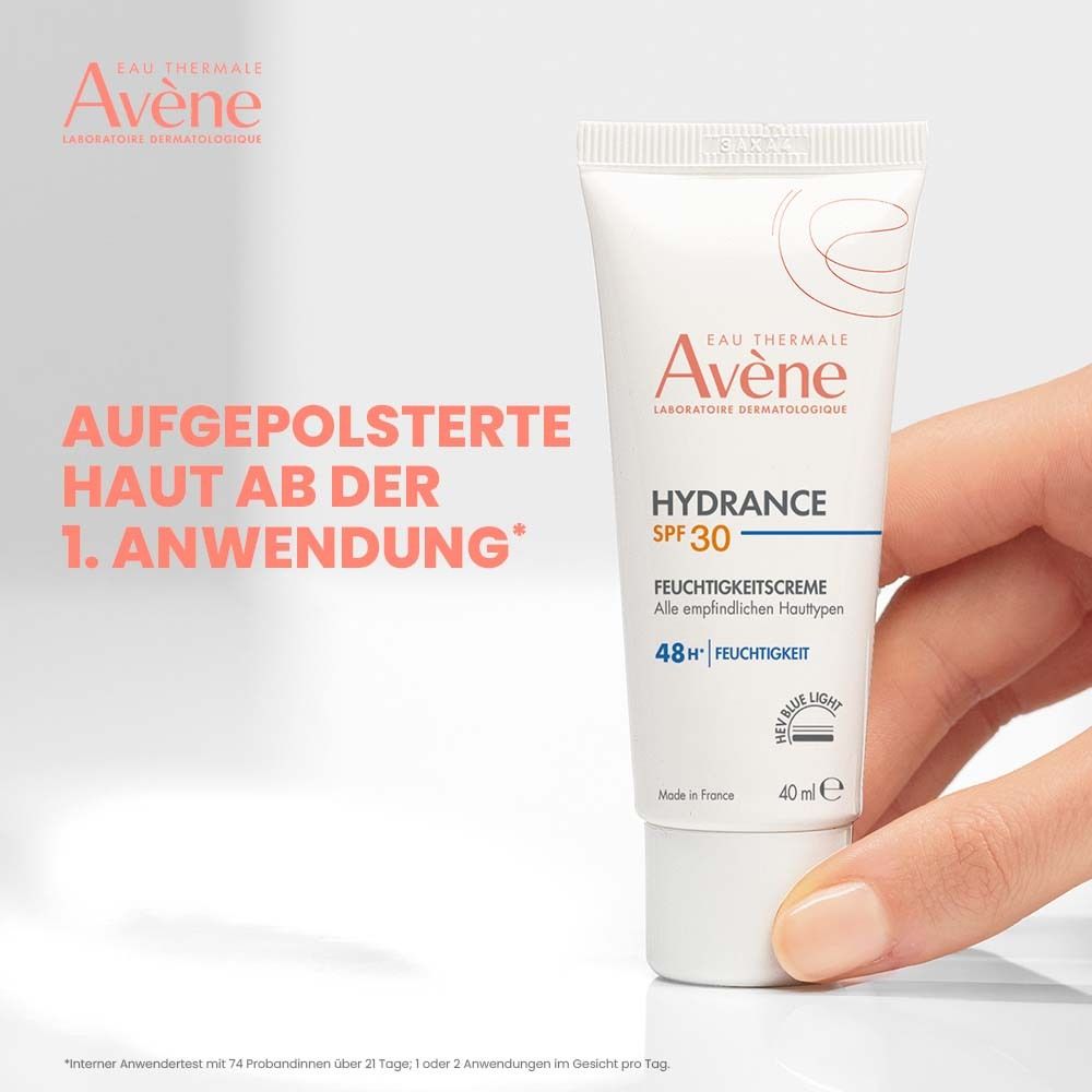 Main tenant un tube Avène Hydrance SPF 30. Texte: Peau repulpée dès la 1ère application.