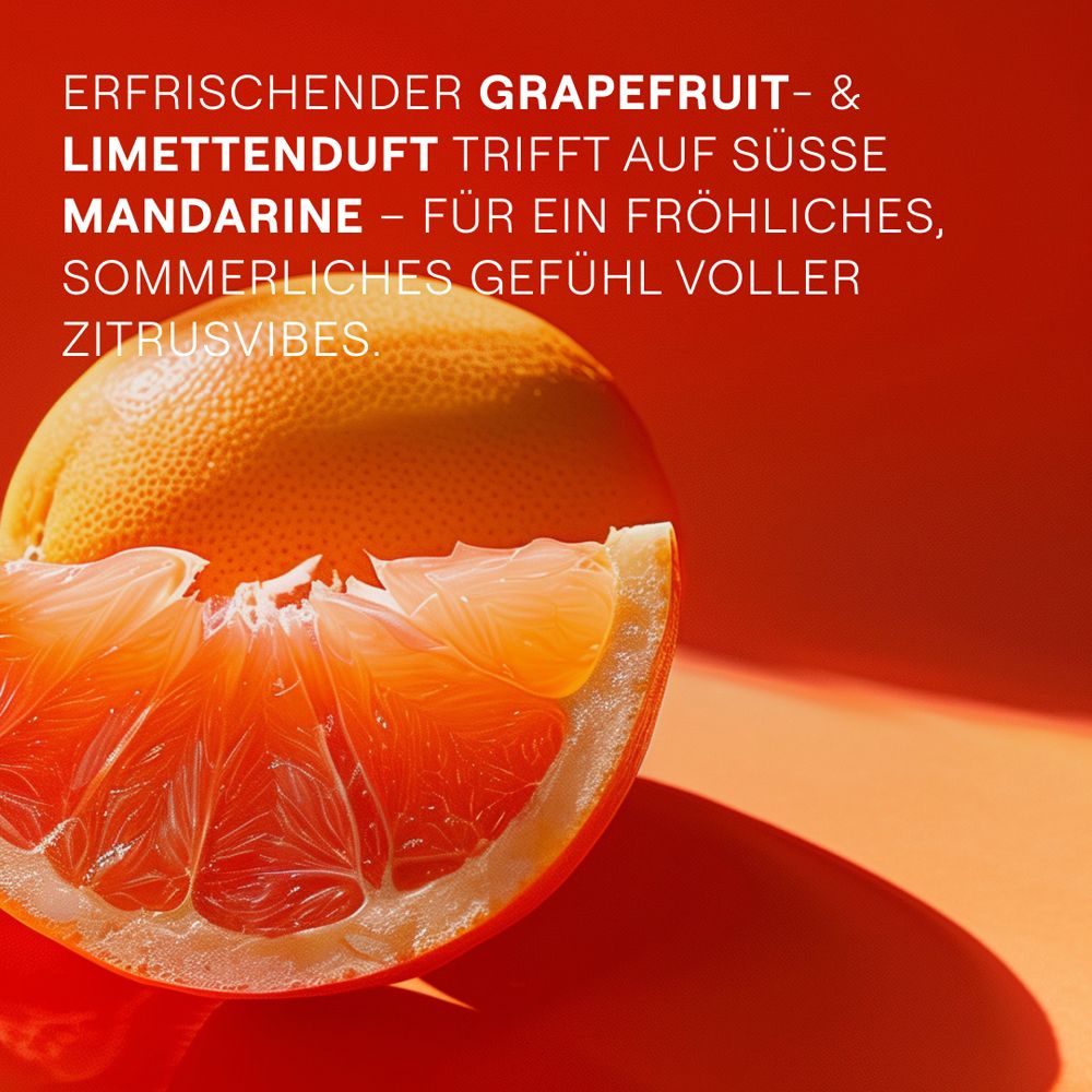Nahaufnahme einer Grapefruit-Hälfte. Roter Hintergrund. Text: Grapefruit- & Limettenduft trifft auf Mandarine.