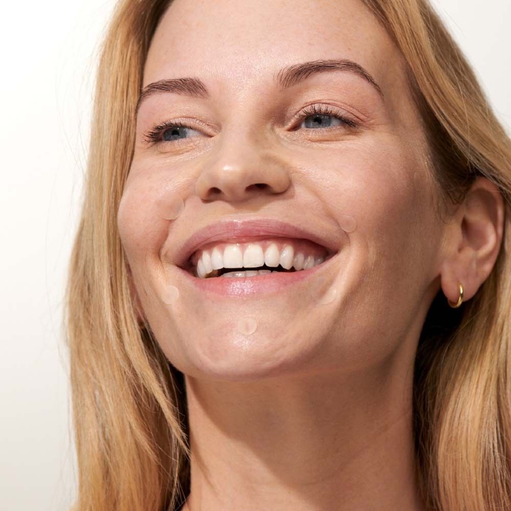 Femme avec des patchs anti-boutons sur la peau. Patchs ronds et transparents. Application.