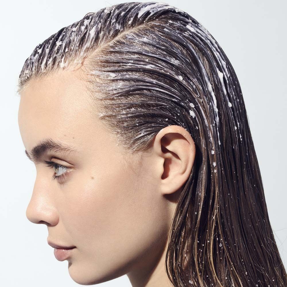 Profil d'une femme aux cheveux mouillés. Un produit est appliqué sur les cheveux. Peau claire.