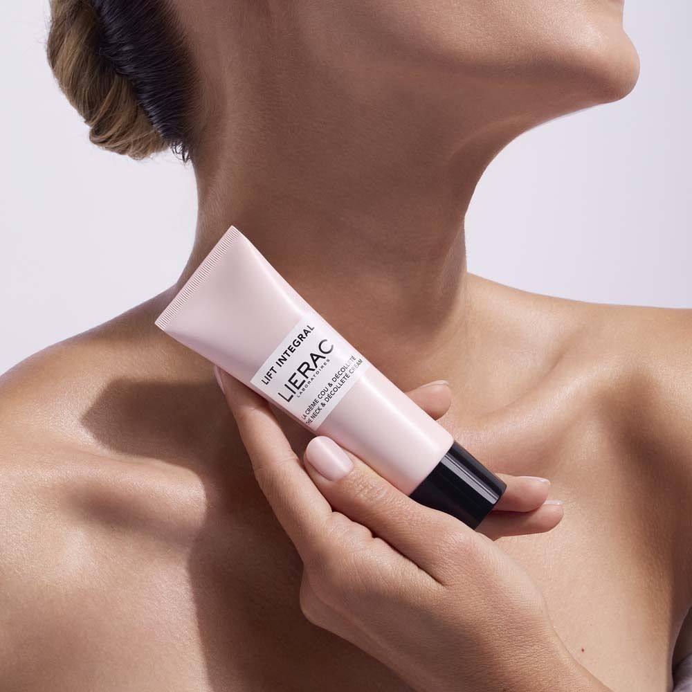 Person hält eine rosa Creme-Tube. Aufschrift: LIFT INTEGRAL, LIERAC, LA CREME COU & DÉCOLLETÉ, THE NECK & DÉCOLLETÉ CREAM.
