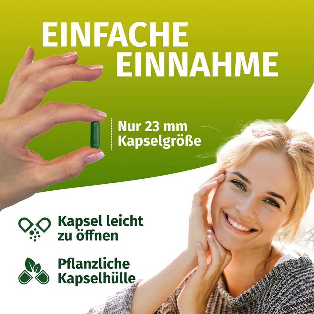 Main tenant une gélule verte (23 mm). Femme souriante. Enveloppe de gélule végétale, facile à ouvrir.