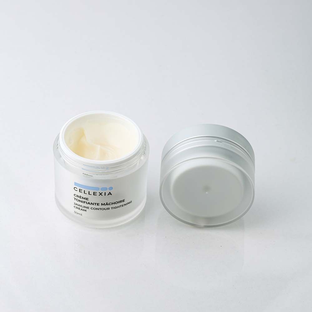 Geöffneter Creme-Tiegel. Creme sichtbar. Aufschrift: Cellexia, Crème Tonifiante Mâchoire, Jawline Contour Tightening Cream. 30ml.