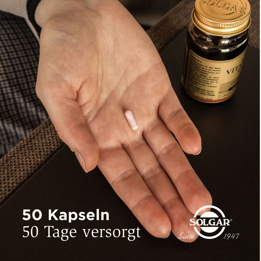 Main avec une gélule. À côté, un flacon de Solgar Vitamine B12. Texte: 50 gélules, 50 jours de fourniture.