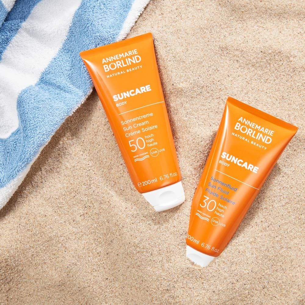 Deux tubes de crème solaire sur sable. Un LSF 50, un LSF 30. Marque : Annemarie Börlind.