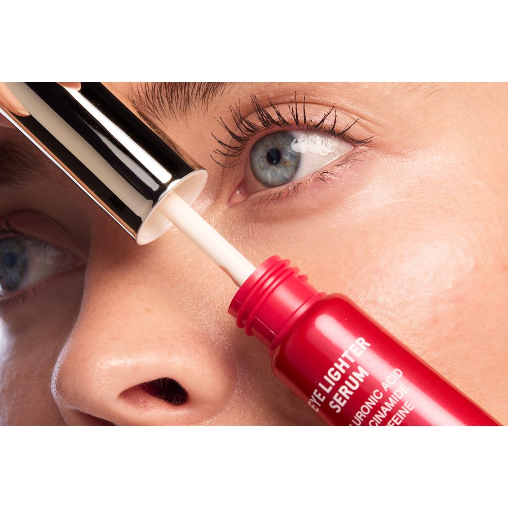 Frau mit Applikator. Serum wird auf die Augenpartie aufgetragen. Rote Tube.