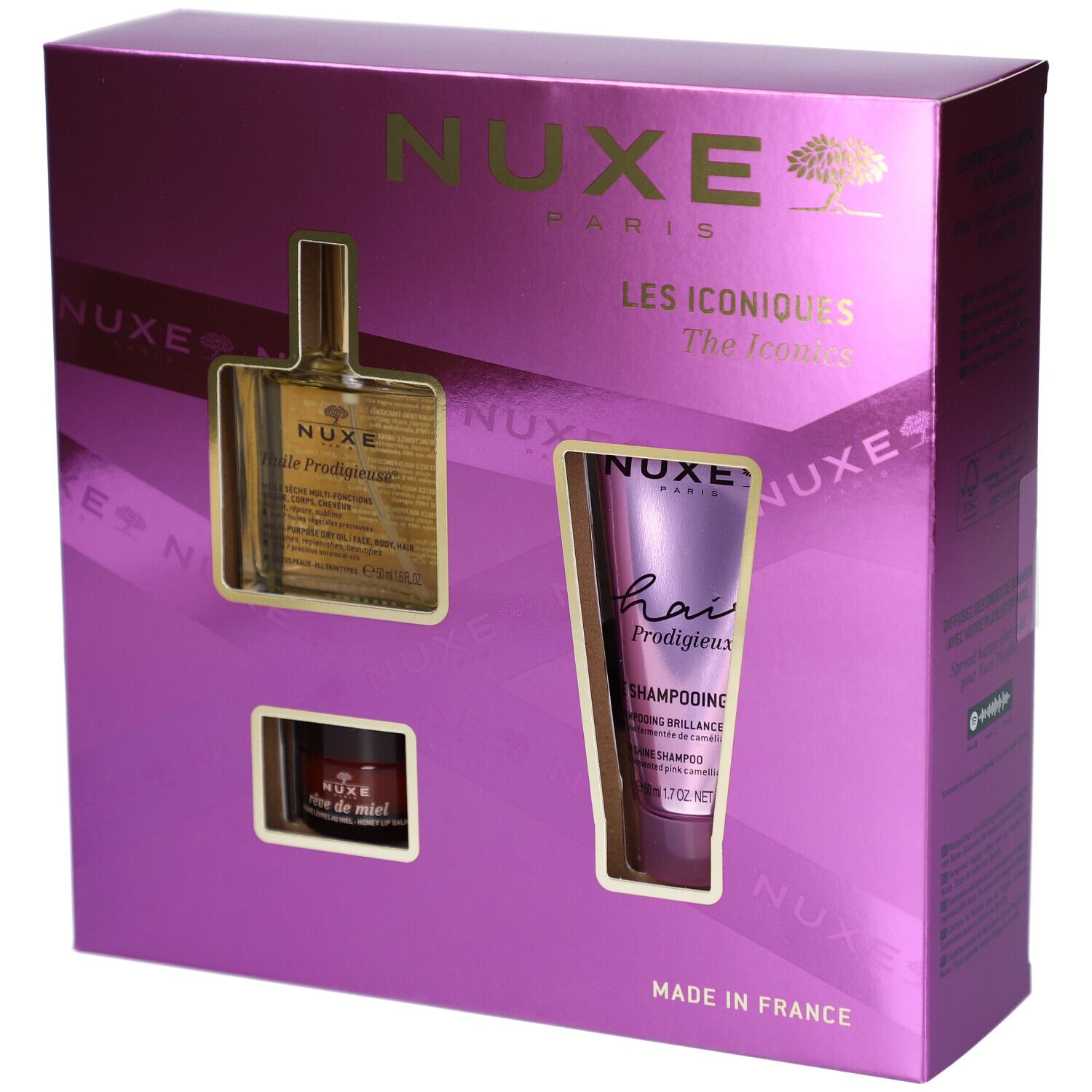 Geschenkset mit drei Produkten in einer lila Schachtel. Sichtbar sind ein Öl, ein Shampoo und eine Creme. Der Markenname NUXE ist sichtbar.