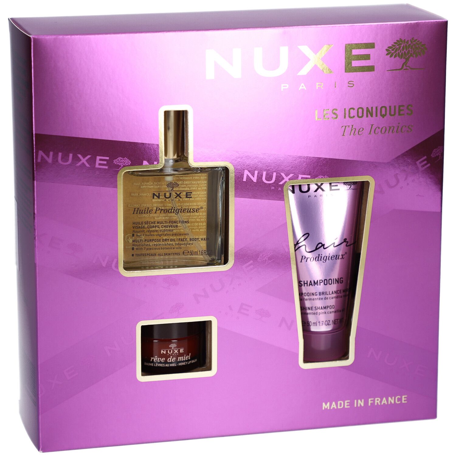 Geschenkset mit drei Produkten in einer lila Schachtel. Sichtbar sind ein Öl, ein Shampoo und eine Creme. Der Markenname NUXE ist sichtbar.