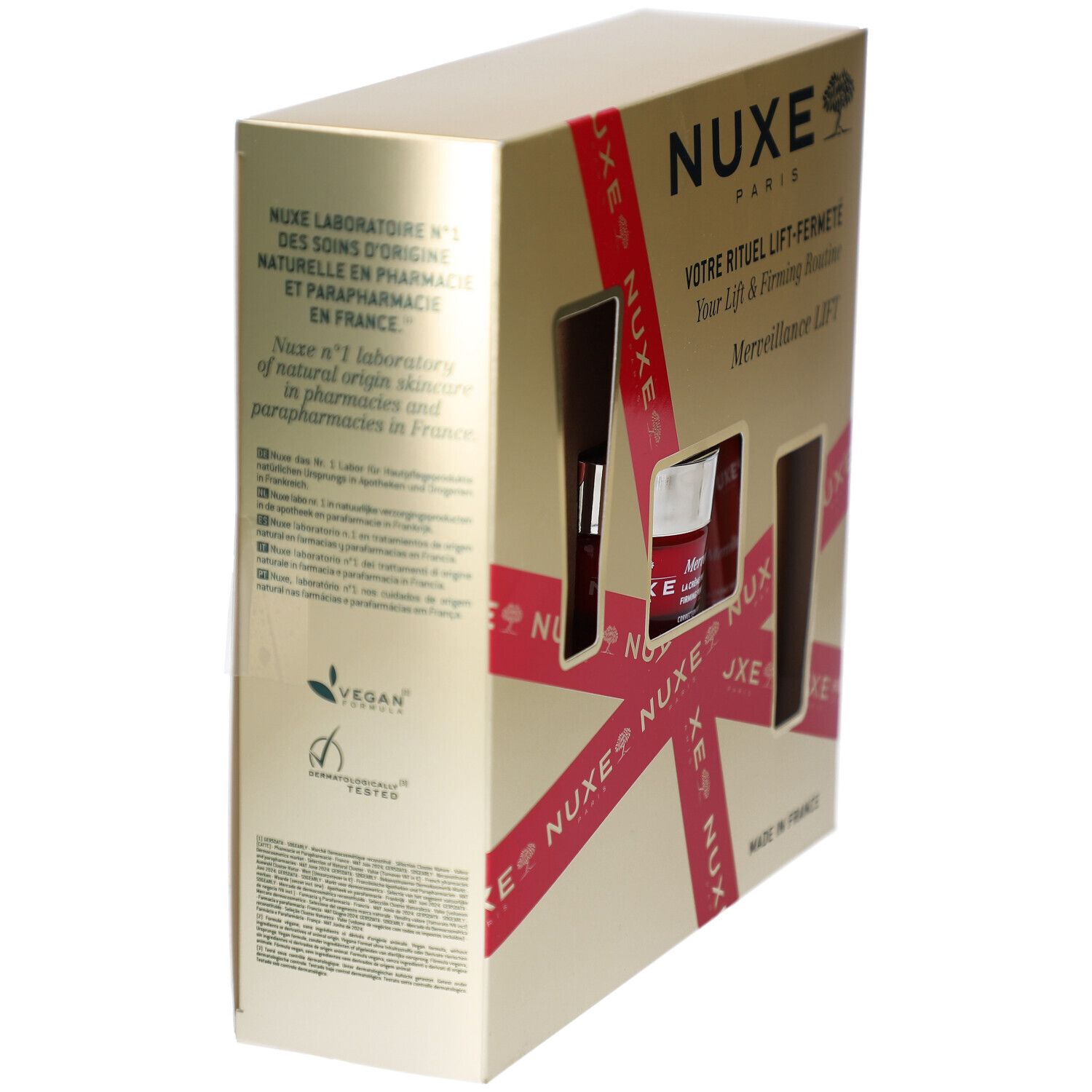 Seitenansicht der Geschenkbox. Goldfarben mit rotem Band und Produktfenstern. NUXE-Logo und Text. Vegan-Logo.