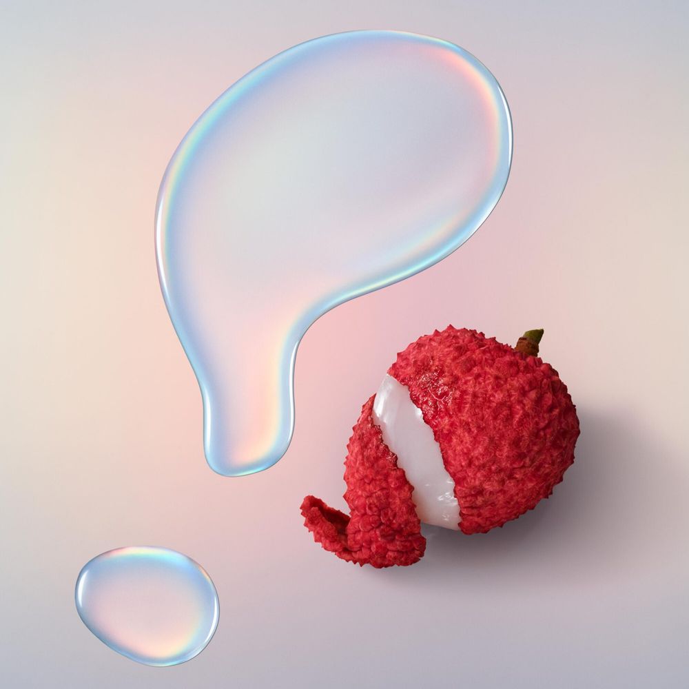 Deux gouttes et un fruit litchi. Gouttes transparentes. Litchi rouge avec chair blanche.