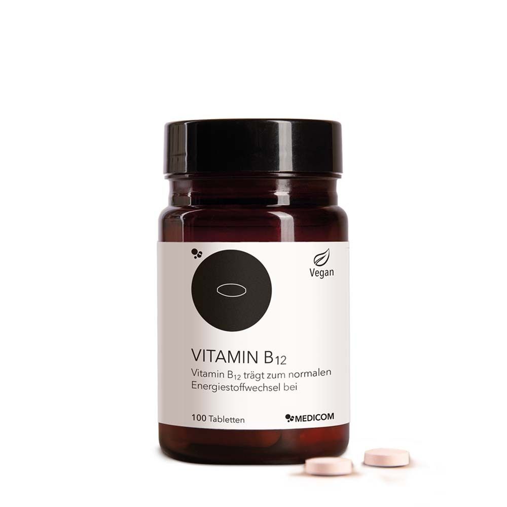 Braune Glasflasche mit schwarzem Deckel. Etikett mit "Vitamin B12" und "100 Tabletten". Zwei Tabletten liegen daneben. Vegan-Siegel.