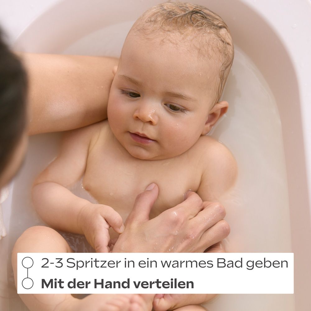 Bébé dans le bain. Mains tenant bébé dans l'eau. Texte: 2-3 pulvérisations dans un bain chaud. Répartir à la main.