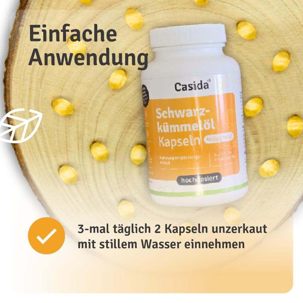 Flasche Casida® Schwarzkümmelöl Kapseln auf Holz. Text: Einfache Anwendung. 3-mal täglich 2 Kapseln unzerkaut mit Wasser.