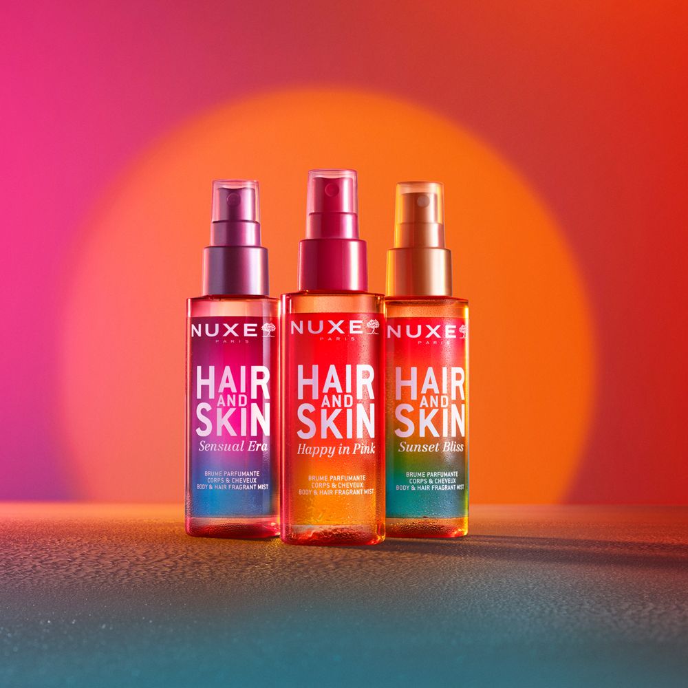 Drei NUXE® Hair and Skin Duftsprays. Farben: Pink, Orange, Gold. Text: Hair and Skin. Verschiedene Düfte.