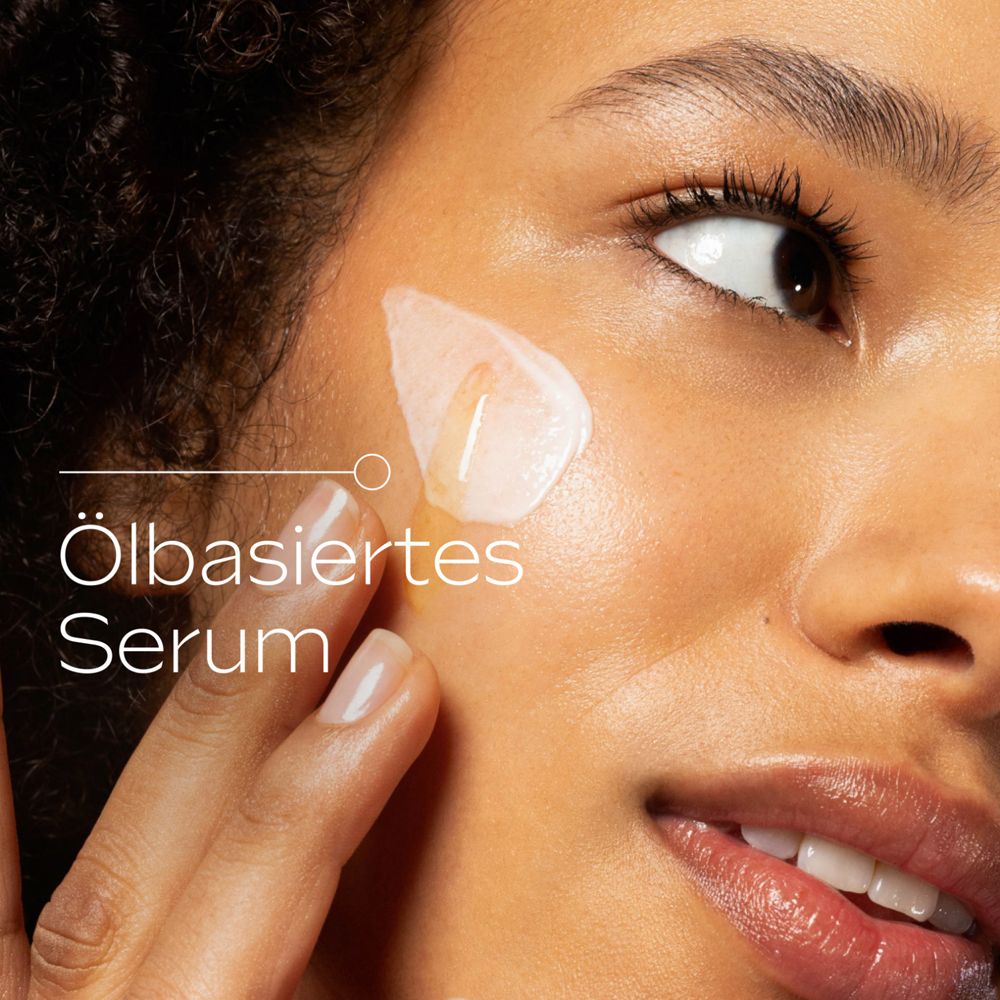 Femme appliquant du sérum. Gros plan. Texte: Sérum à base d'huile.