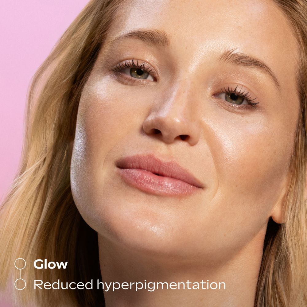 Frau mit strahlender Haut. Text: Glow. Reduzierte Hyperpigmentierung. Rosa Hintergrund.