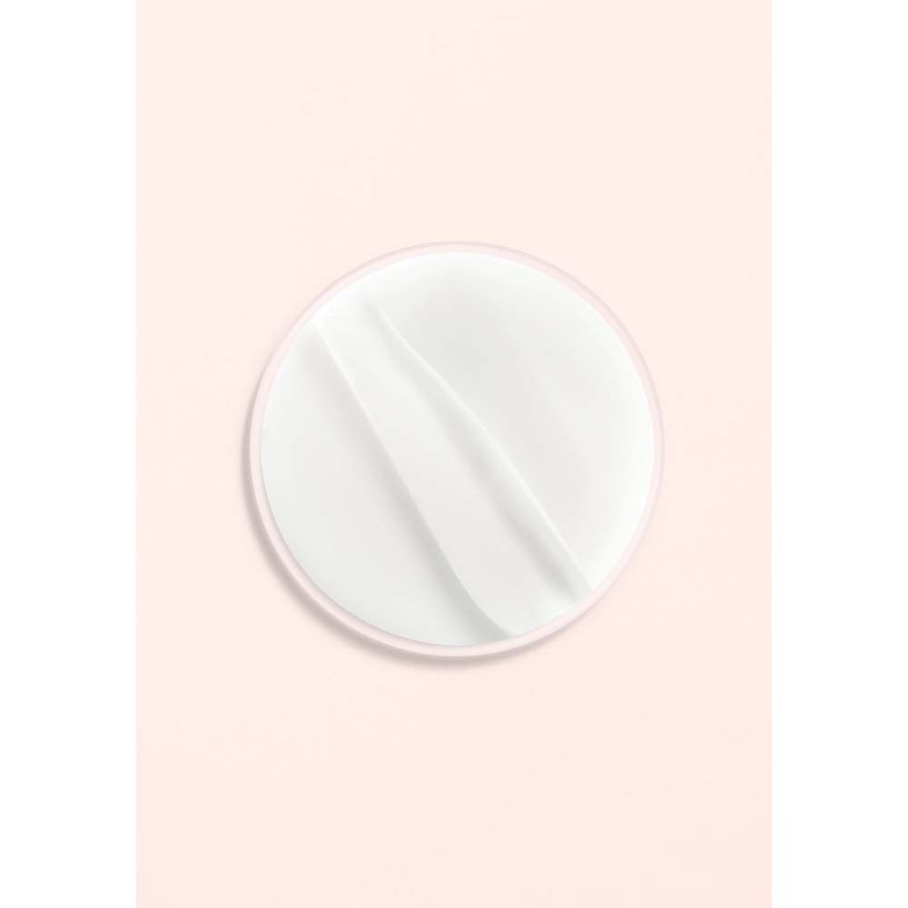 Produit blanc sur fond rose. Forme ronde avec deux stries.