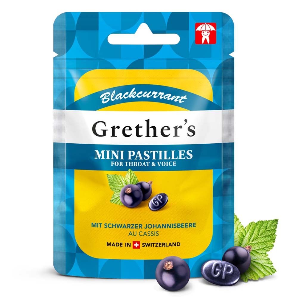 Beutel mit Pastillen, daneben Beeren und Blätter. Aufschrift: Grether's Mini Pastillen, Schwarze Johannisbeere. Logo: Zahn mit Regenschirm. Hergestellt in der Schweiz.
