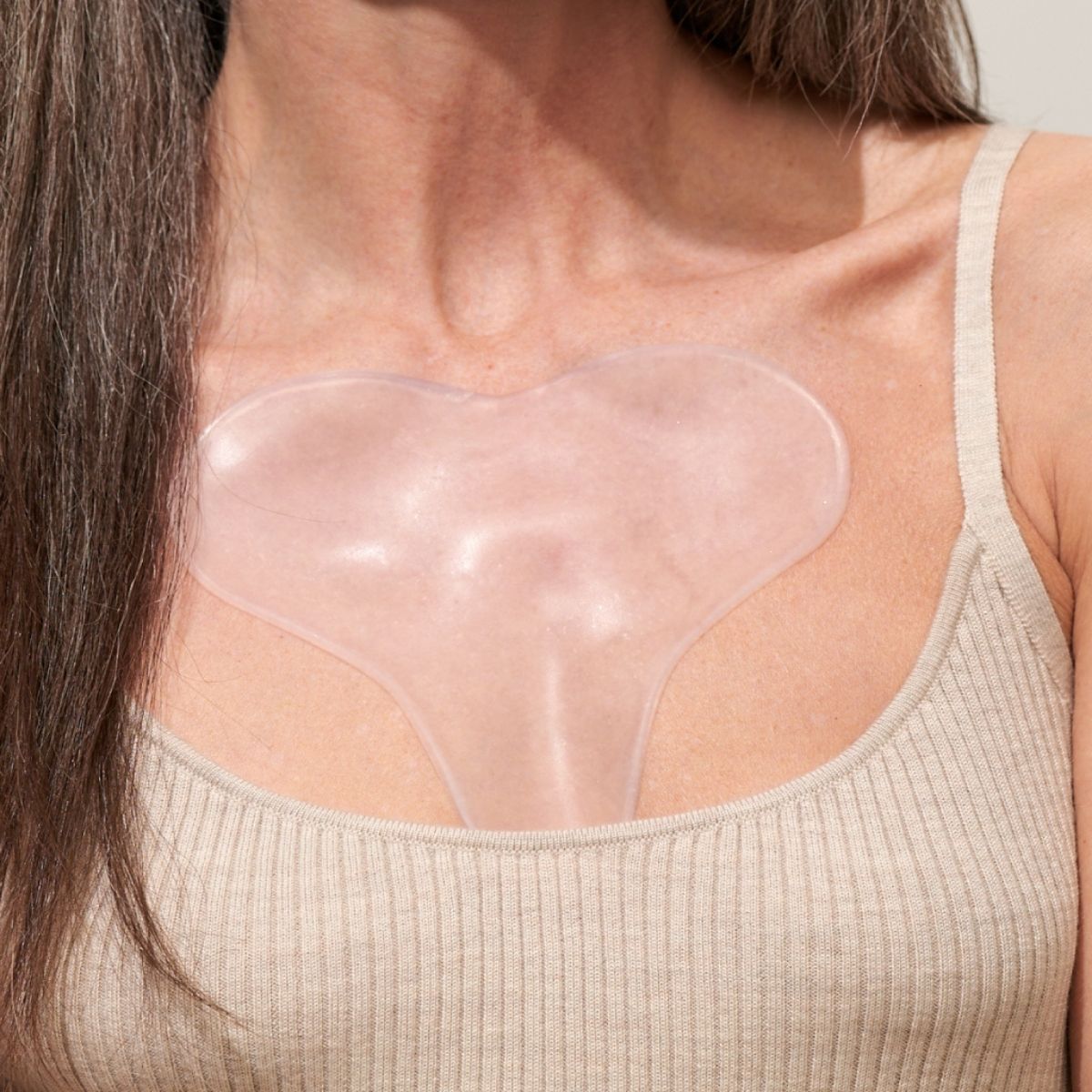 Eine Frau trägt ein transparentes Dekolleté-Pad mit Hyaluron.