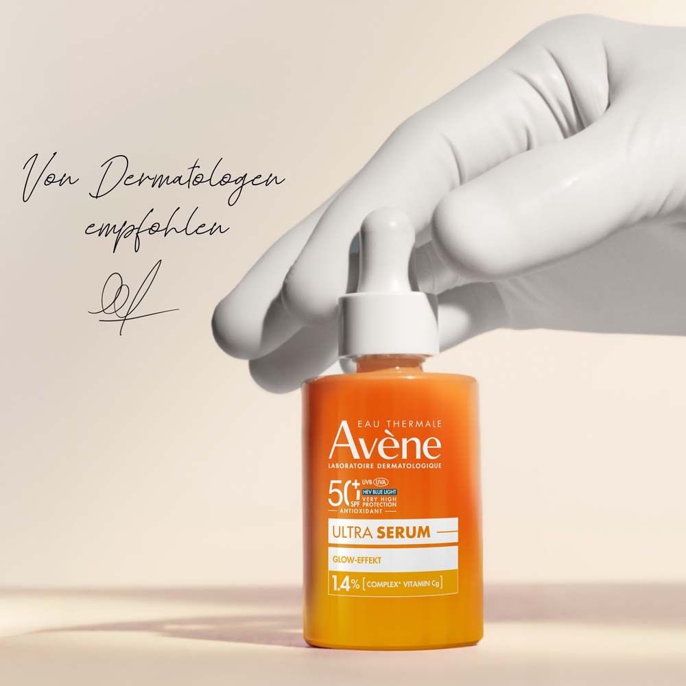 Hand mit Avene Ultra Serum Flasche. Text: Von Dermatologen empfohlen. Flasche: Ultra Serum, Glow-Effekt, 1.4% Complex Vitamin Cg.