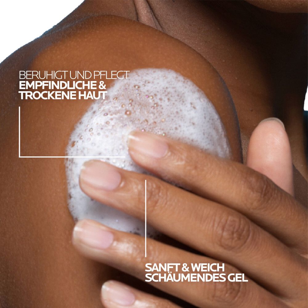 Personne avec de la mousse sur l'épaule. Texte: Apaise et prend soin des peaux sensibles et sèches. Gel moussant doux.