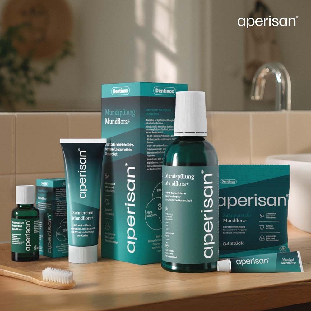 Arrangement de produits. Différents produits aperisan® sur une surface en bois. Dentifrice, bain de bouche, gel buccal.