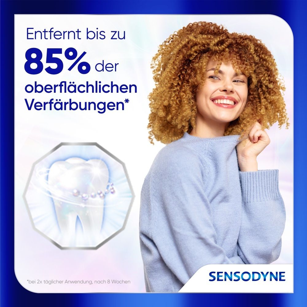Frau mit vollem Haar lächelt, Sensodyne entfernt bis zu 85% oberflächliche Verfärbungen.
