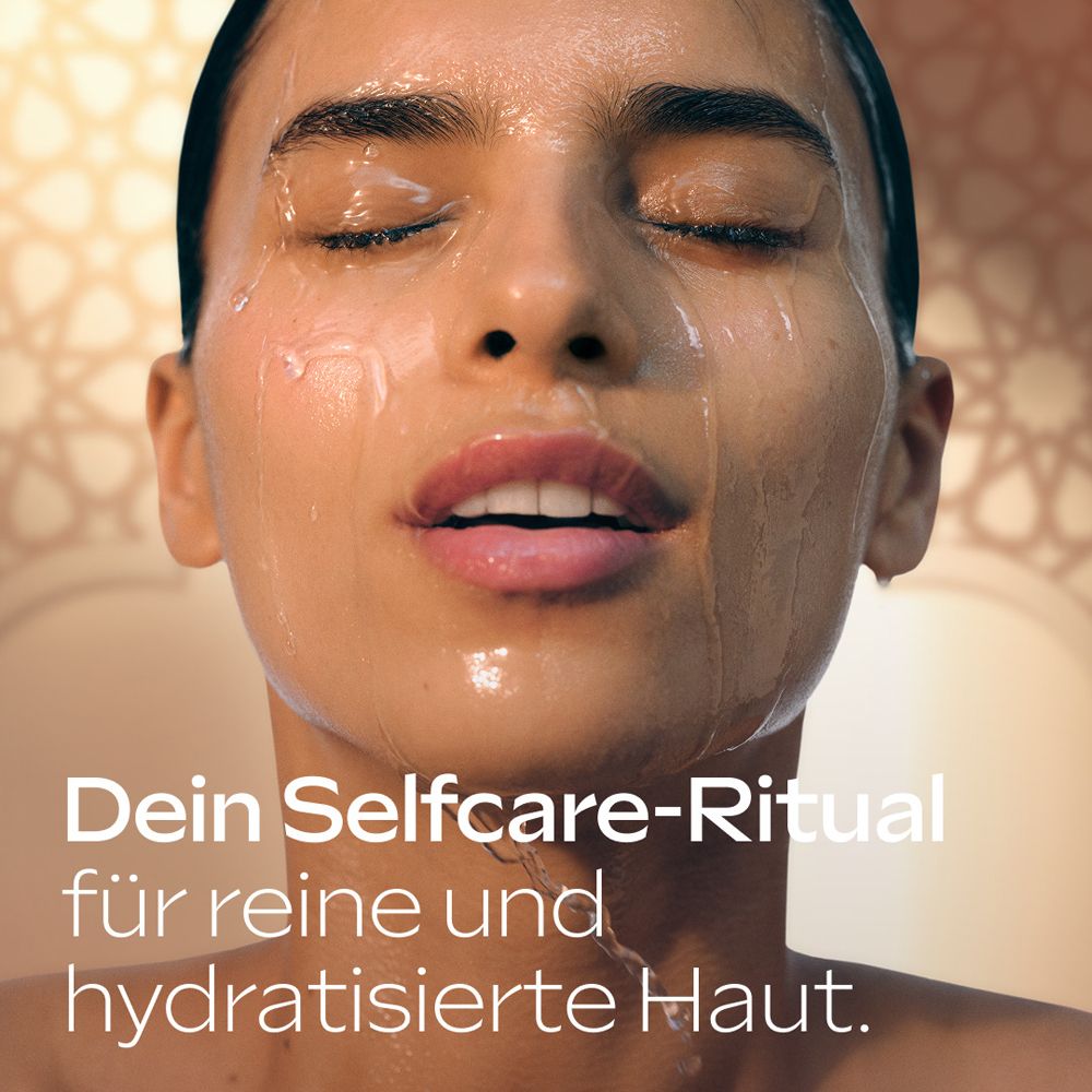 Une femme profite d'un rituel de soin pour une peau pure et hydratée avec la crème de douche Weleda.