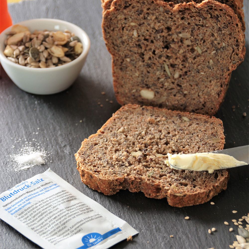 Brot mit Butter, Salzstreuer und Tütchen Dr. Jacob's Blutdruck-Salz. Aufschrift.