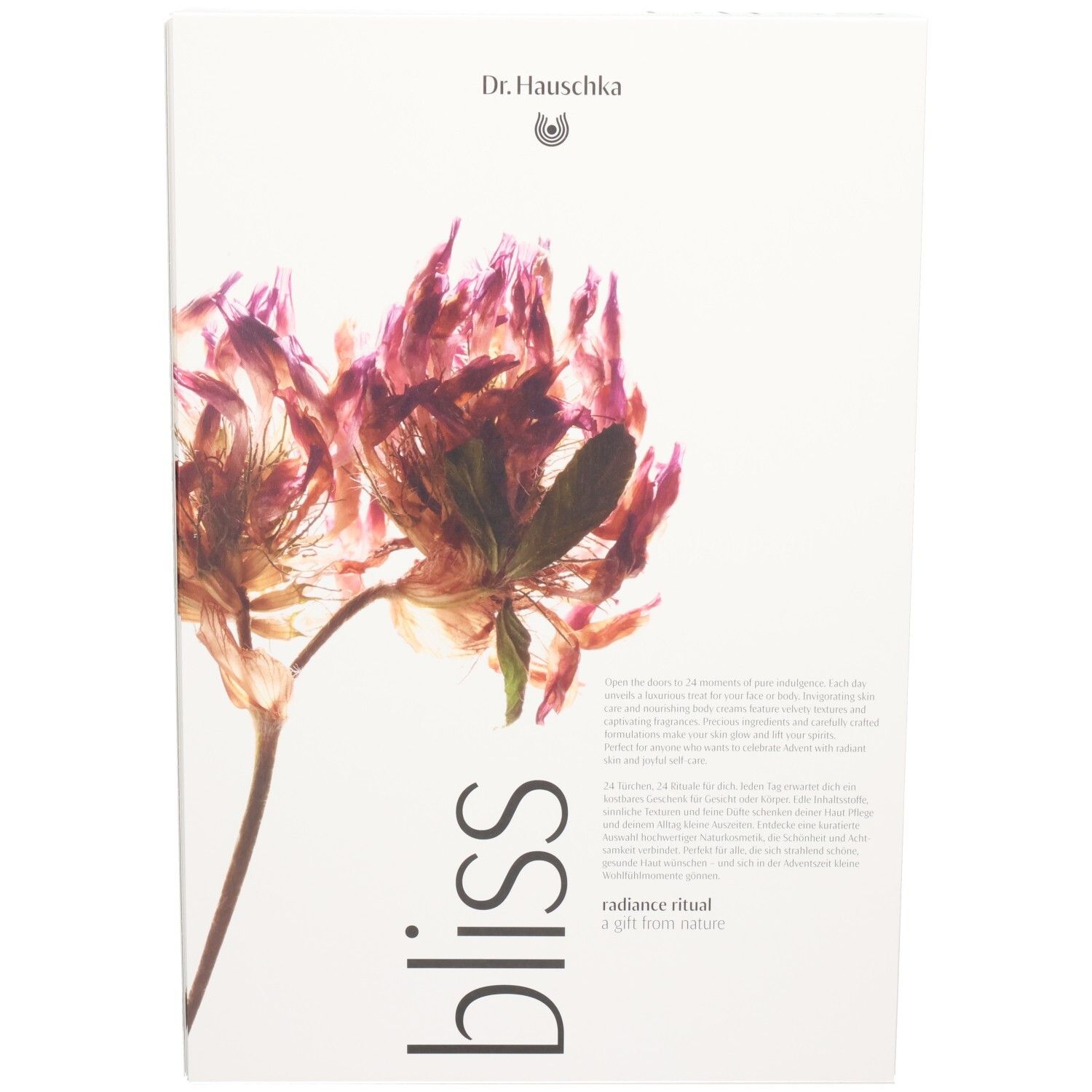 Dr. Hauschka Bliss Radiance Ritual Geschenkbox mit getrockneter Blüte.