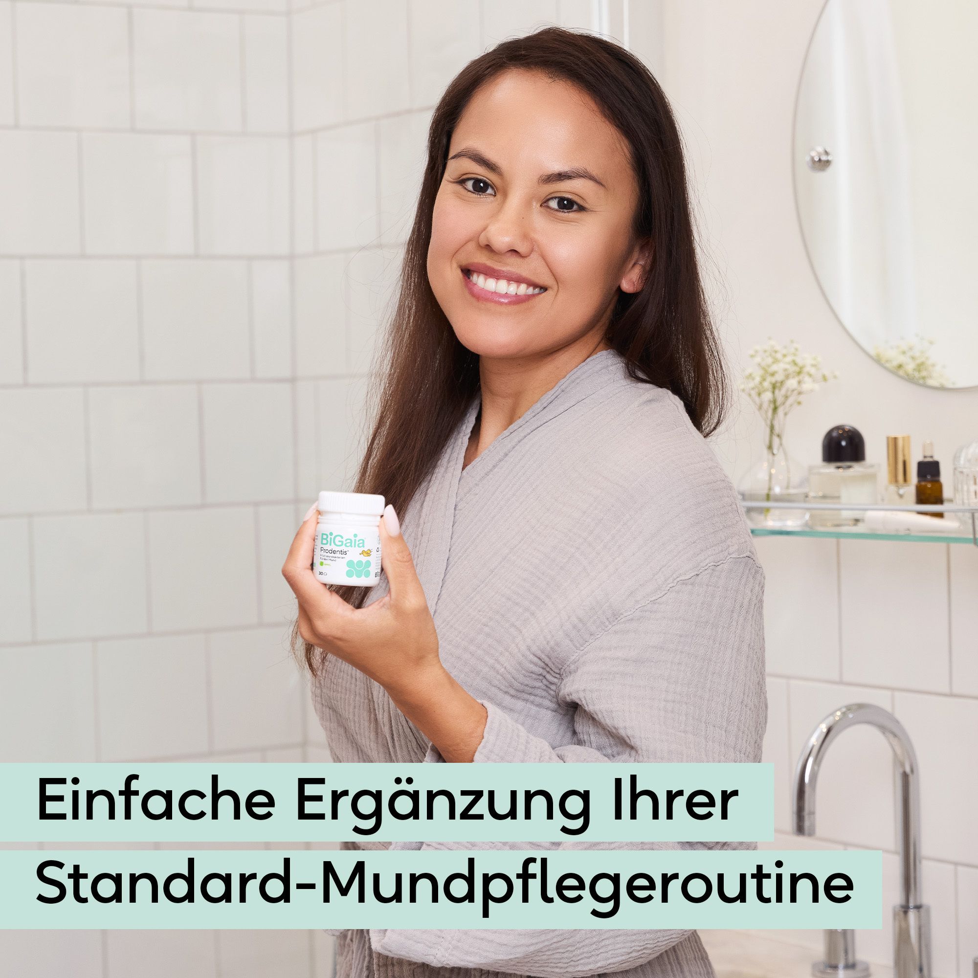 Frau hält eine kleine weiße Dose mit einem grünen Etikett. Badezimmerumgebung.